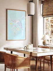 Illustrative manta ray with floral pattern and separate flower bouquet on light blue background, in a styled room mockup