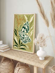 Illustrative marbled white butterfly on plant against olive green background botanical art, in an alternate framed mockup