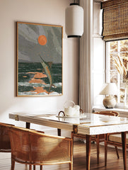 Illustrative art print of a marlin jumping from dark ocean waves under an orange sun in a grey sky, in a styled room mockup