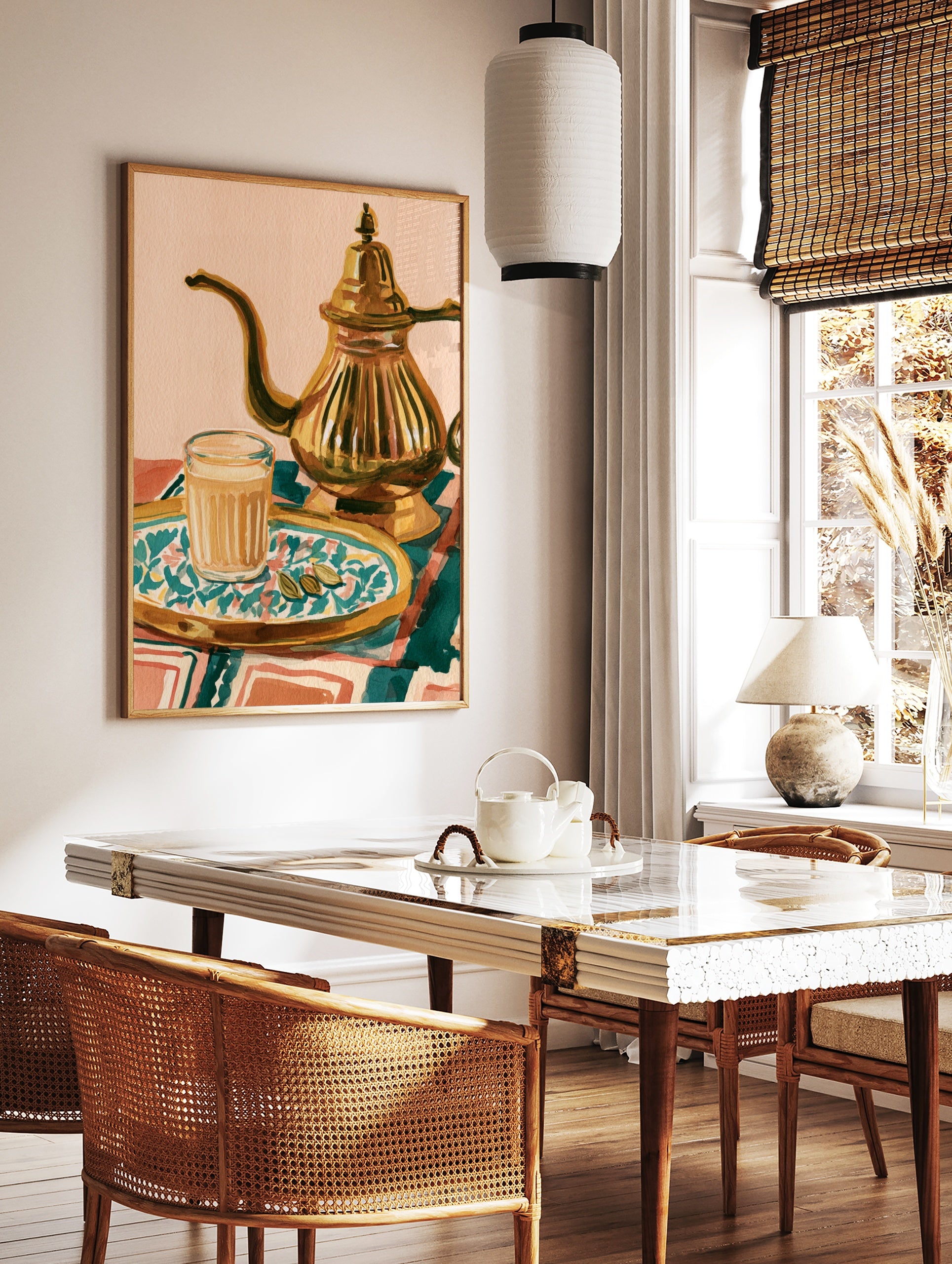 Illustrative art print of a glass of masala chai, a metallic teapot, and cardamom pods on a, in a styled room mockup