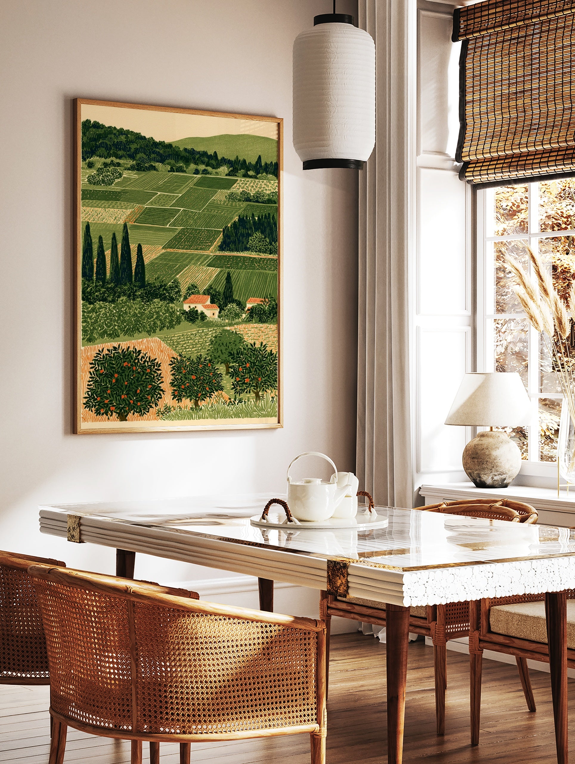 Illustrative rural landscape print with green agricultural fields, cypress trees, and orange fruit, in a styled room mockup