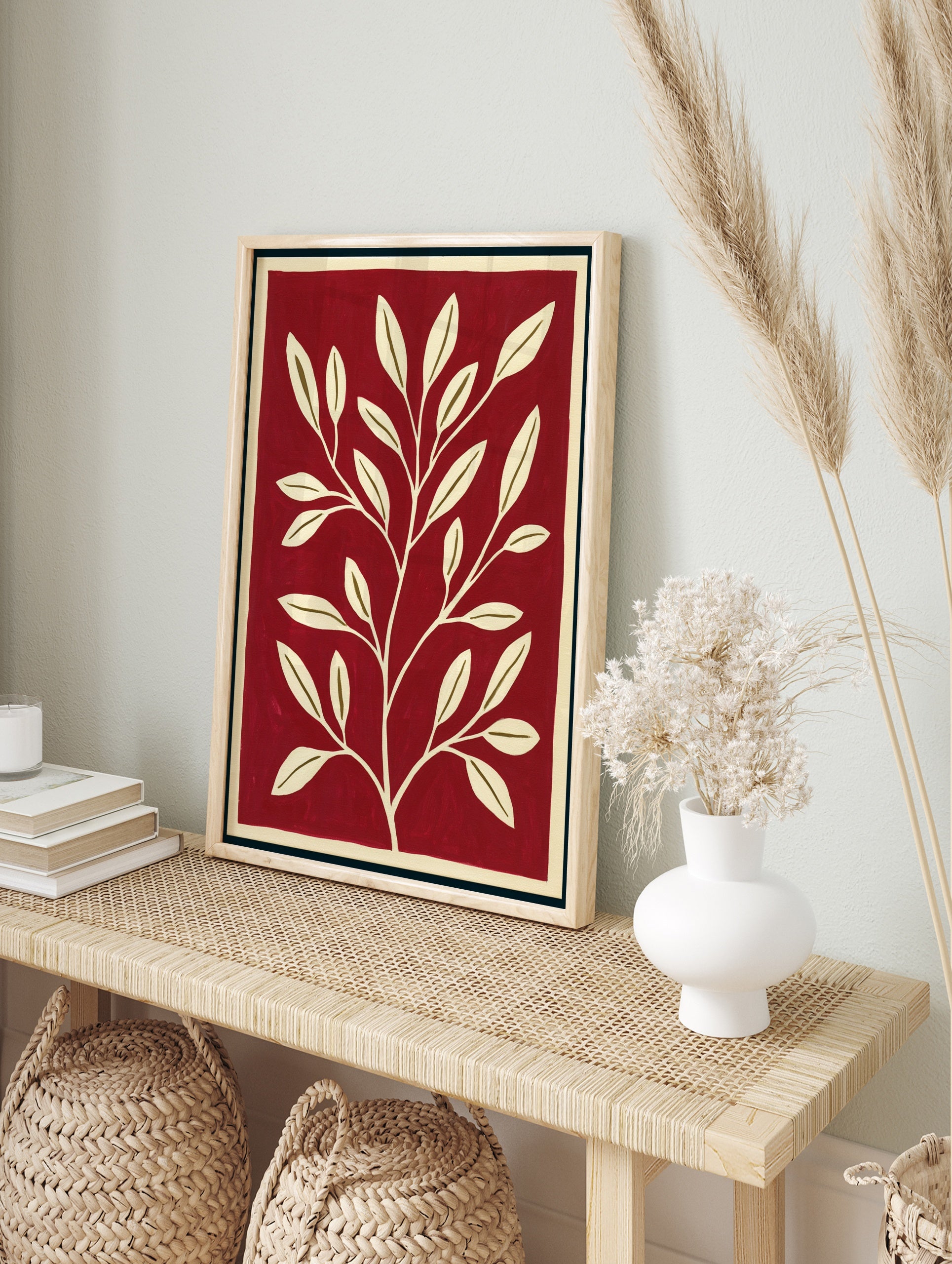 Minimalist botanical wall art with a cream-coloured leafy branch on a solid deep red, in an alternate framed mockup