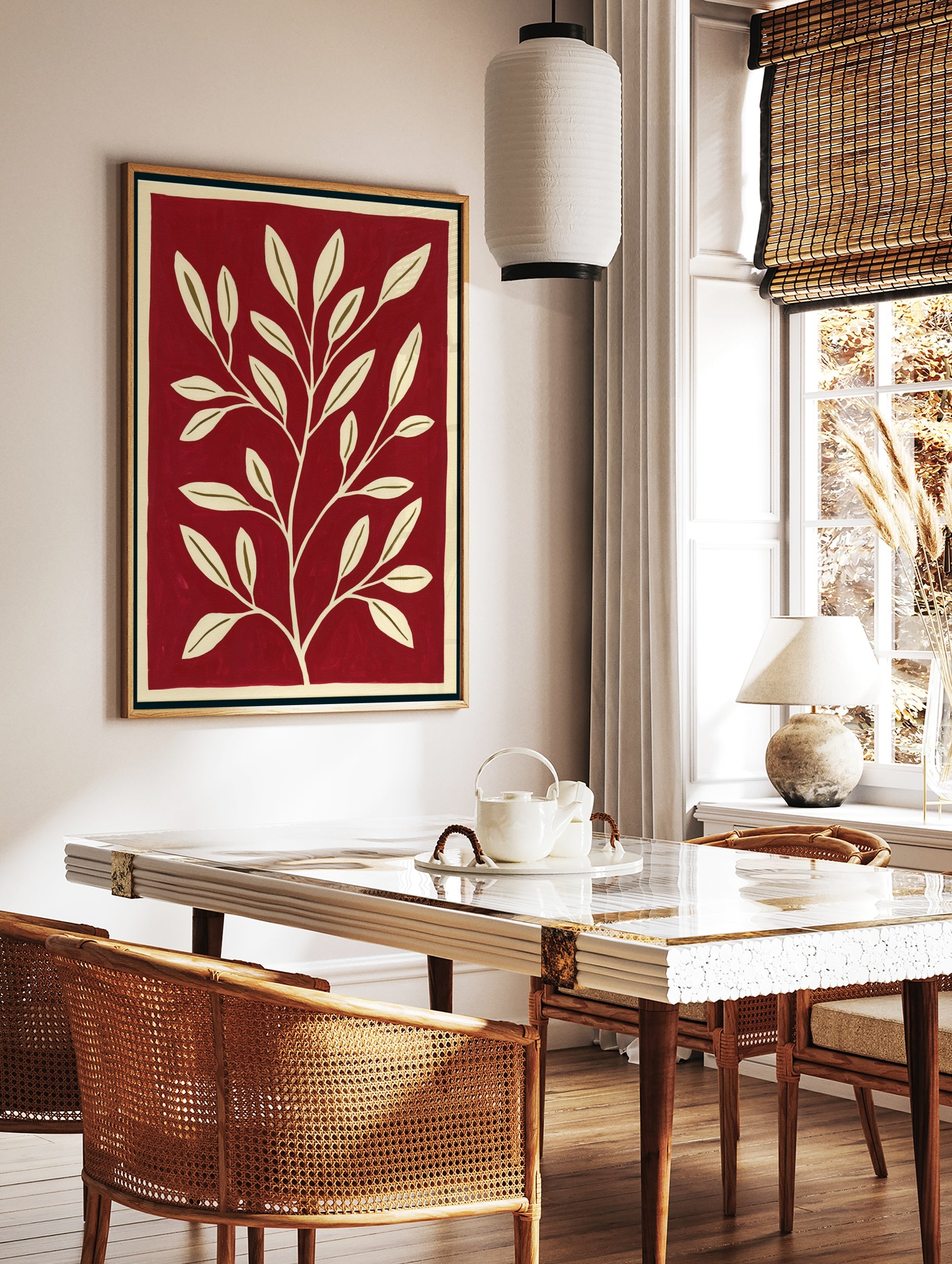 Minimalist botanical wall art with a cream-coloured leafy branch on a solid deep red background, in a styled room mockup