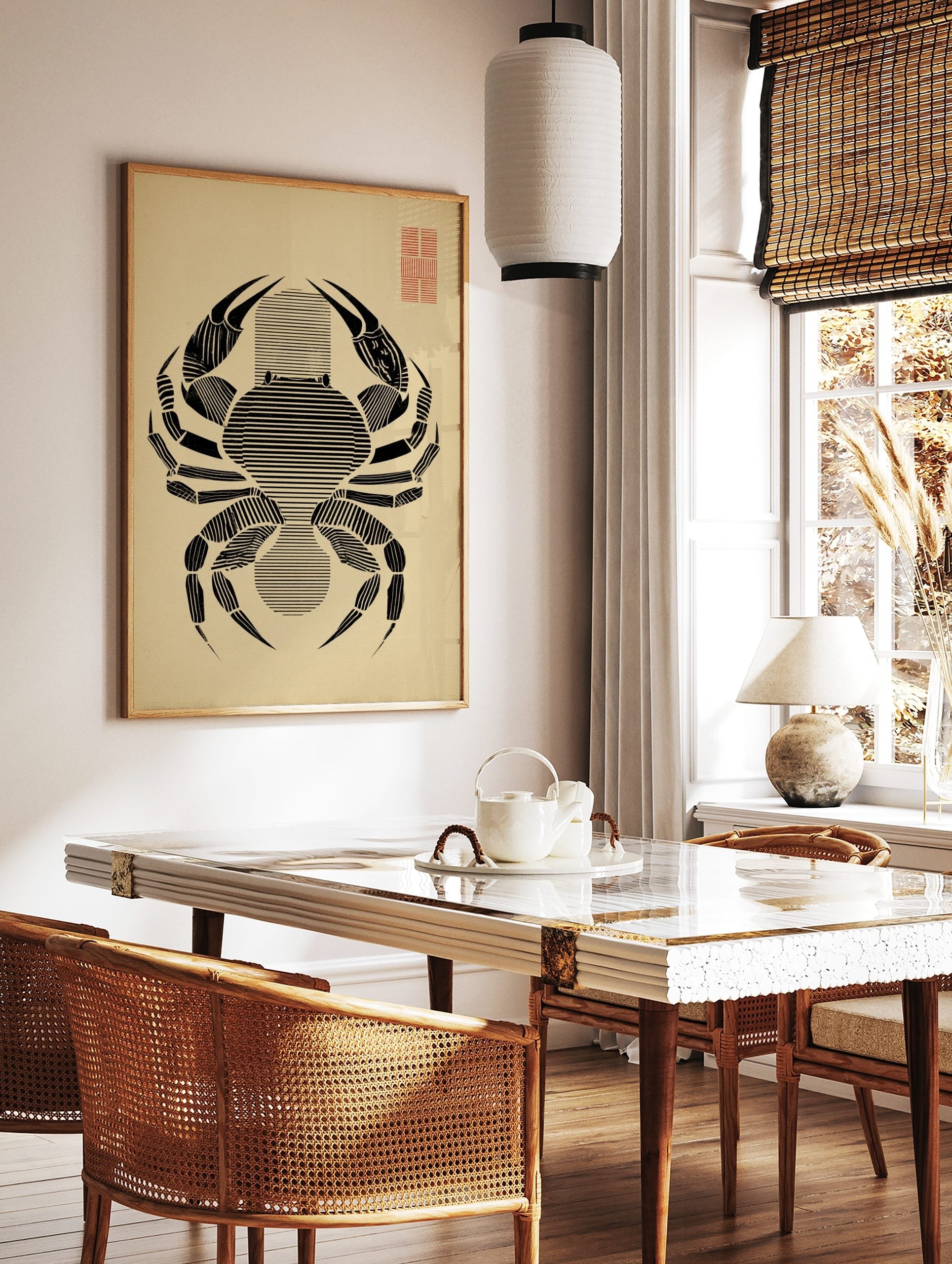 Minimalist black crab illustration with horizontal lines on beige paper, red grid in top right, in a styled room mockup