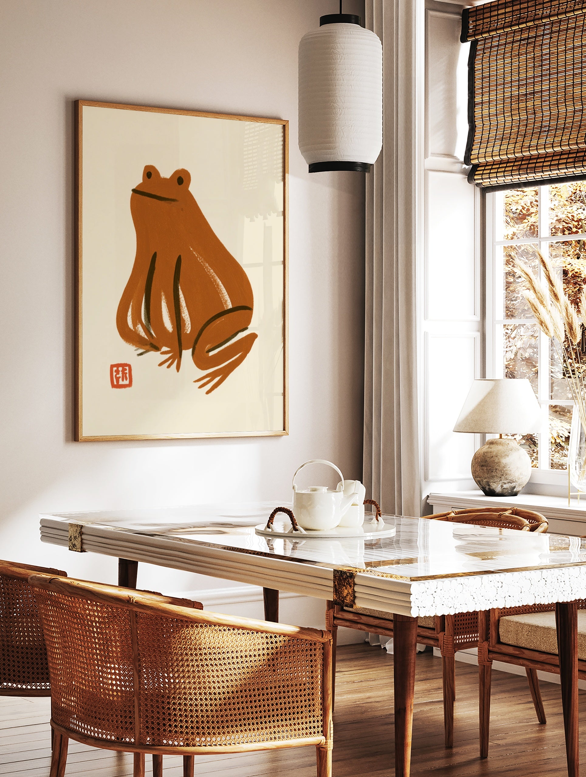 Minimalist brown frog illustration with a small red stamp on a cream background, illustrative style, in a styled room mockup