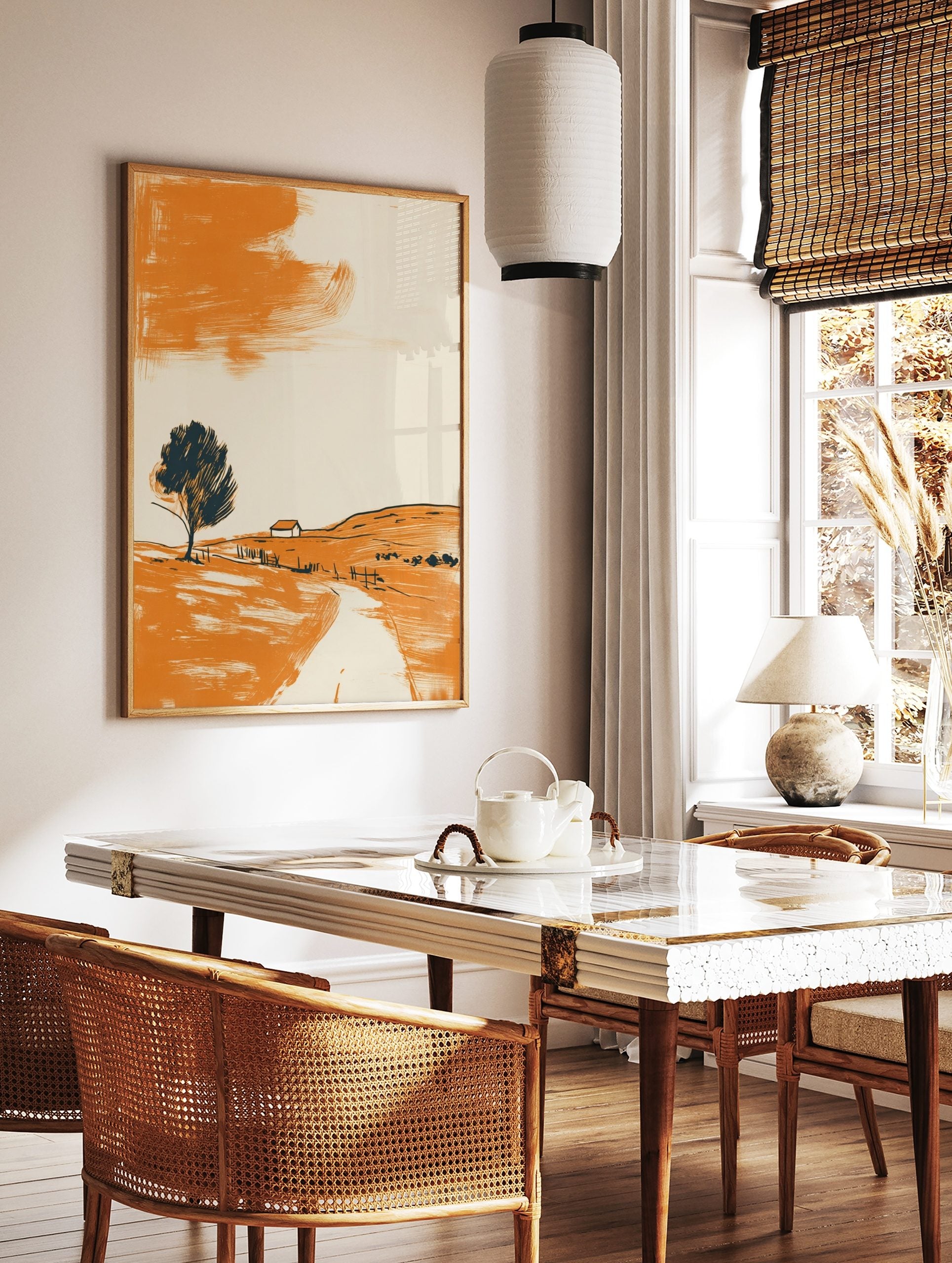 Minimalist landscape art print with orange hillside, dark tree, small house, and abstract orange sky, in a styled room mockup