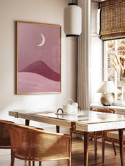 Minimalist moon landscape art print featuring a cream crescent moon above rolling pink and berry, in a styled room mockup
