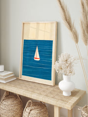 Minimalist sailboat wall art illustration featuring a white boat on a deep blue sea with, in an alternate framed mockup