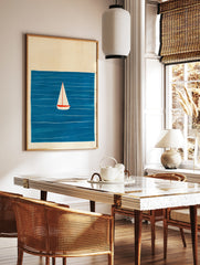 Minimalist sailboat wall art illustration featuring a white boat on a deep blue sea with simple, in a styled room mockup