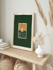 Minimalist sailboat art print with white boat on dark green sea and tan sky, illustrative, in an alternate framed mockup