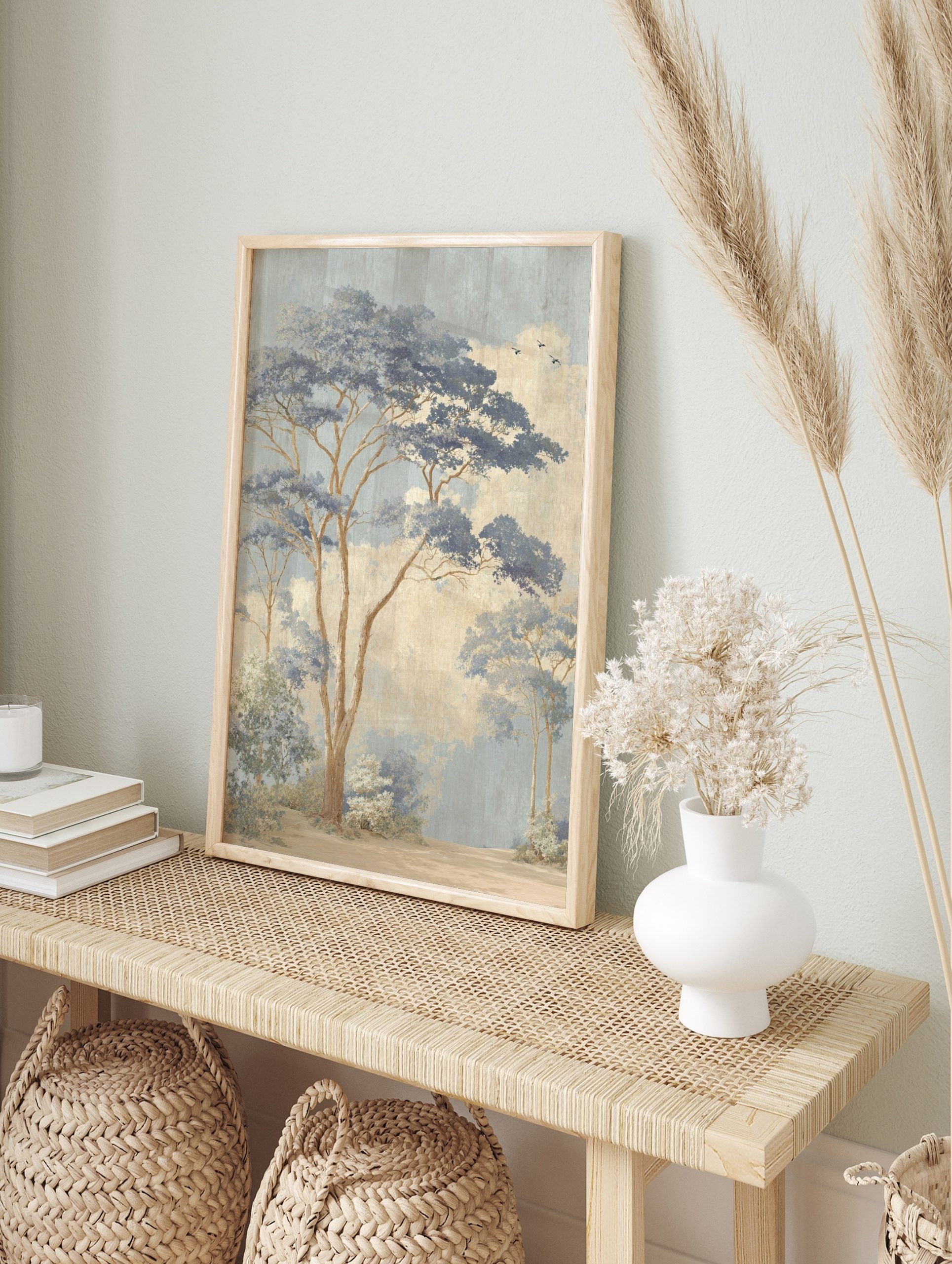 Illustrative misty blue forest landscape art print with tall trees, blue foliage, beige sky, in an alternate framed mockup
