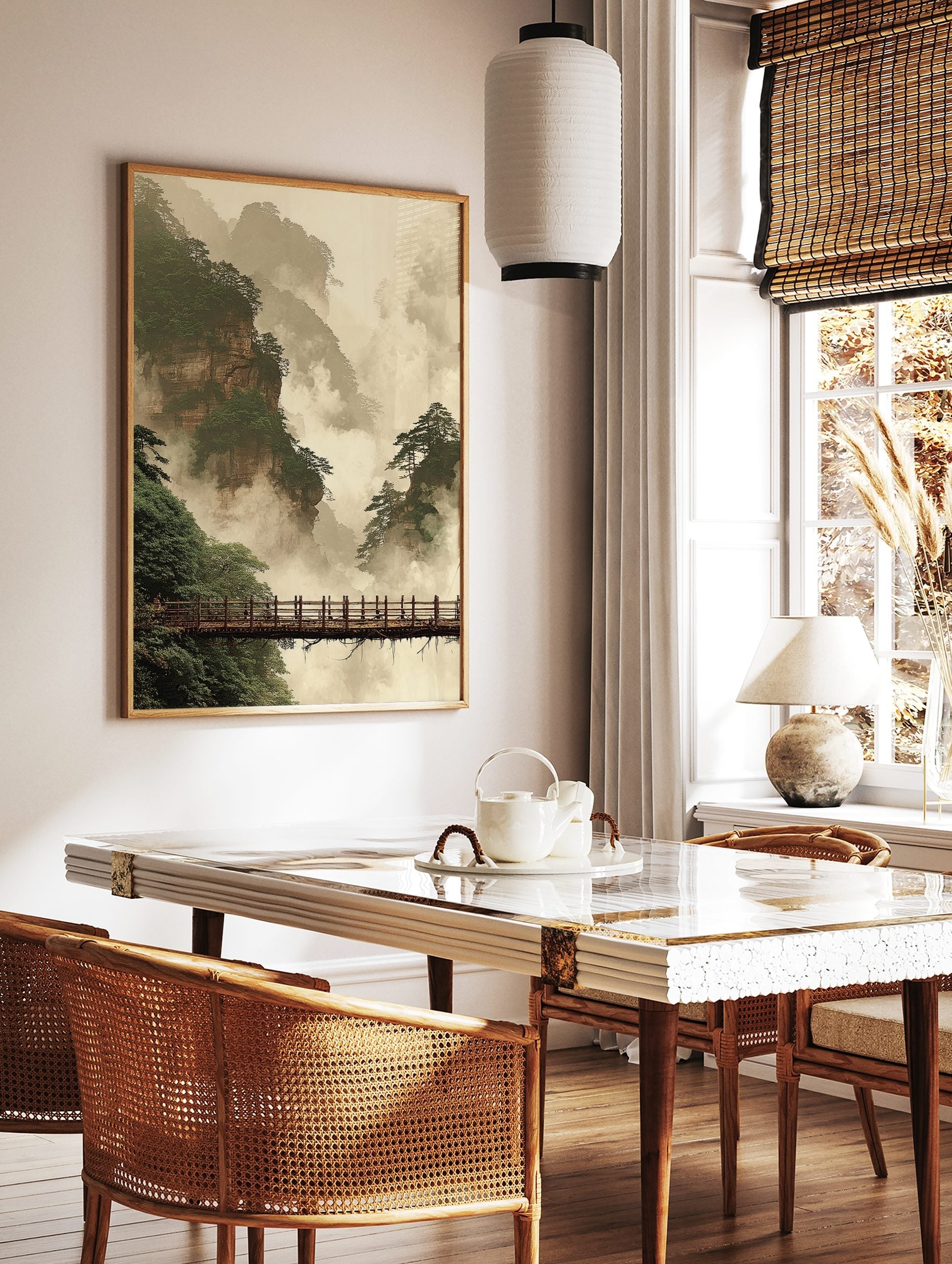 Misty mountain landscape art print with towering cliffs, green pine trees, and a wooden bridge in, in a styled room mockup