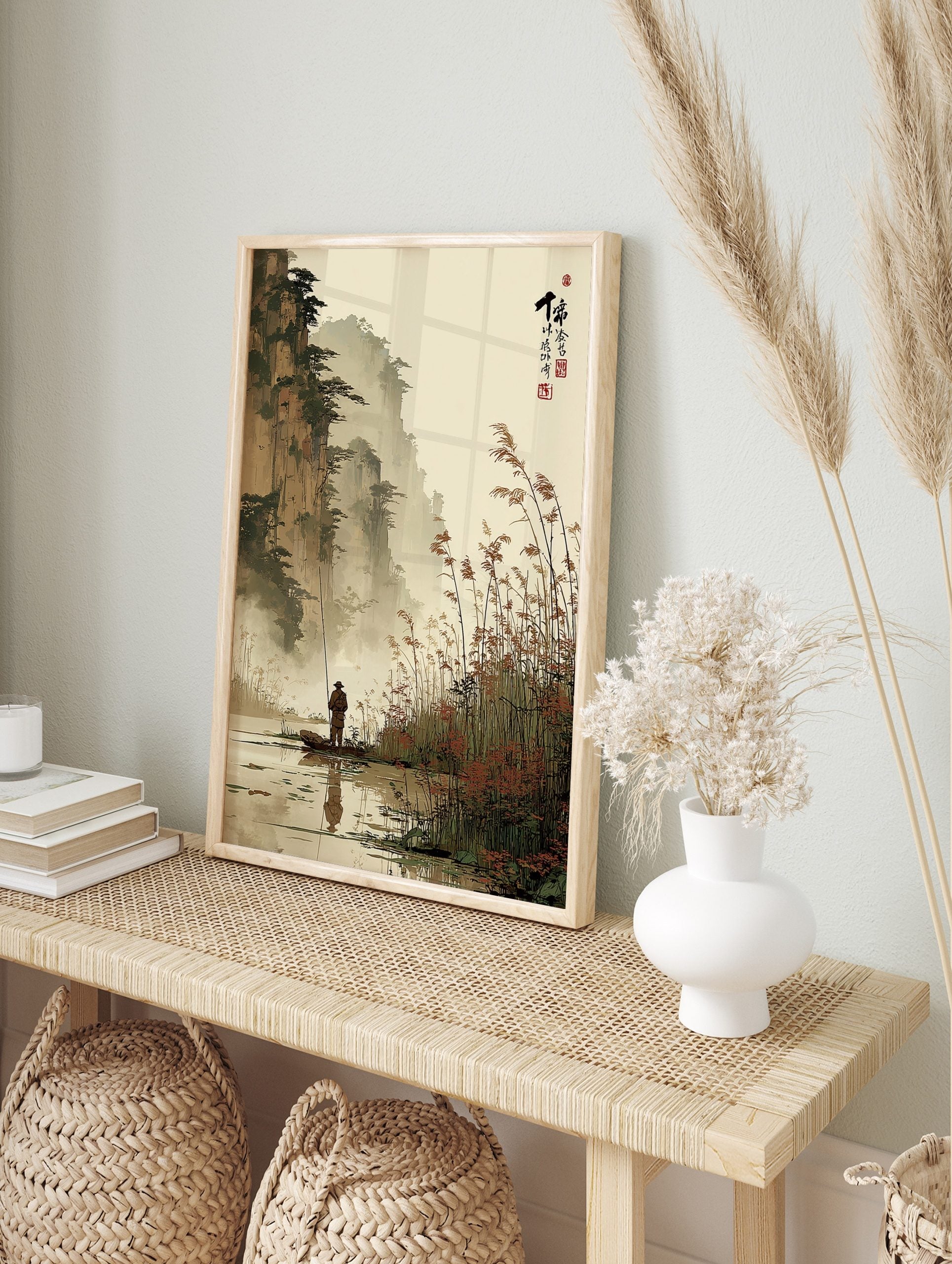 East Asian ink wash landscape print of a fisherman in a boat with misty mountains and reeds, in an alternate framed mockup