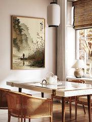 East Asian ink wash landscape print of a fisherman in a boat with misty mountains and reeds, in a styled room mockup