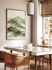 Watercolour painting of a layered misty mountain range with snow-capped peaks in green and white, in a styled room mockup