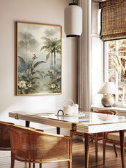 Misty tropical jungle art print with large green leaves, palm trees, a small bird, and white flowers, in a styled room mockup