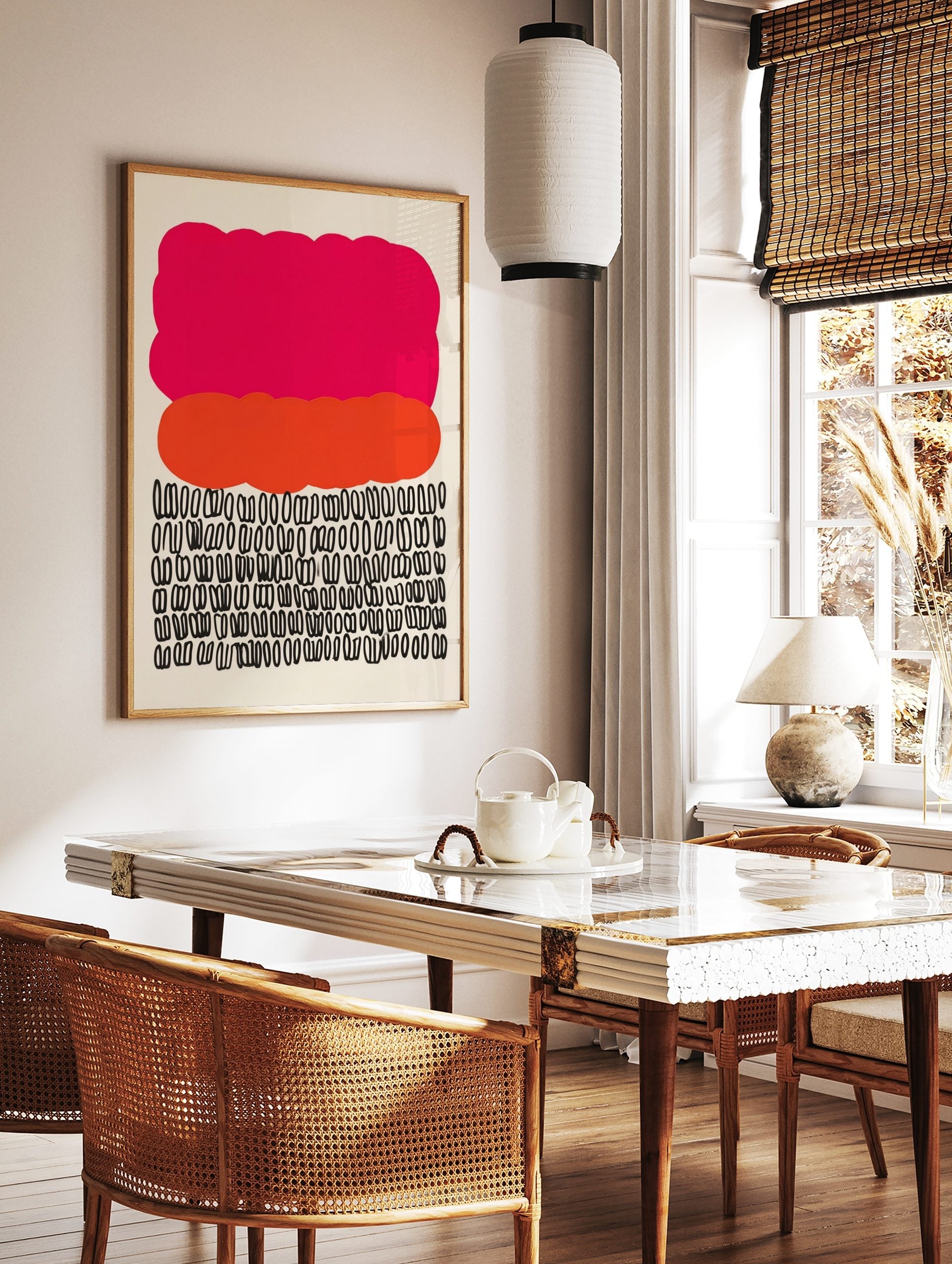 Abstract art print with a large pink cloud shape, an orange organic shape, and rows of black looped symbols, in a styled room