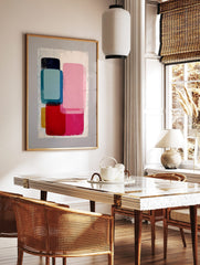 Abstract geometric wall art print with stacked rounded rectangular shapes in pink, blue, red, and, in a styled room mockup
