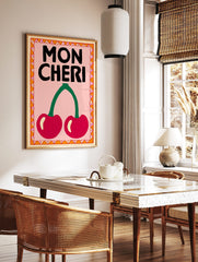 Mon Cheri typography wall art with two red cherries, green stem, pink background, and decorative, in a styled room mockup