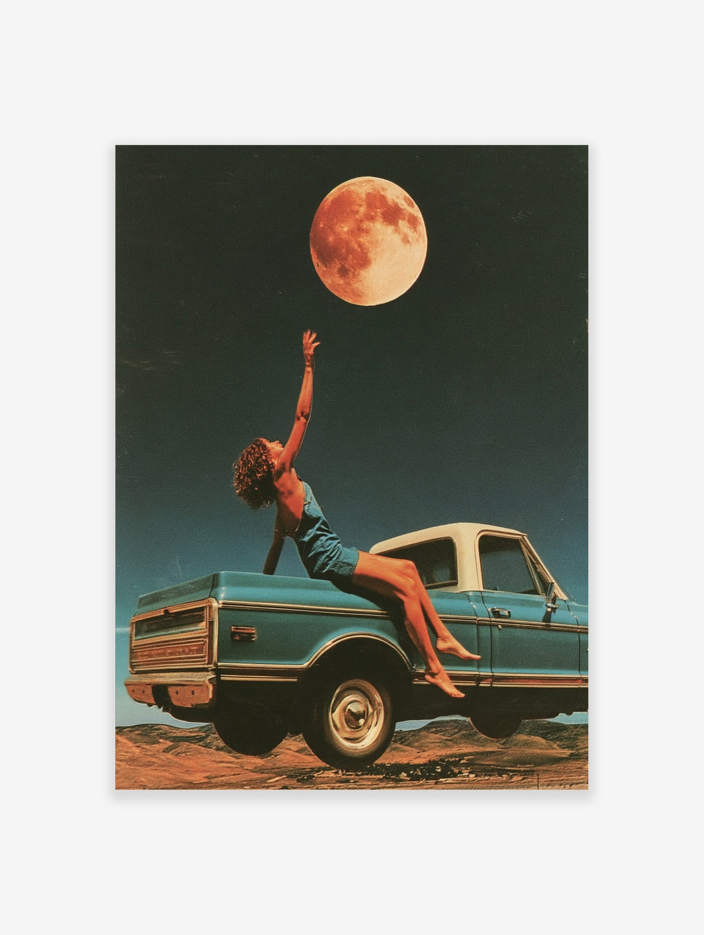 Surreal art print of a person reaching for a glowing moon from a floating vintage blue pickup truck in a desert landscape