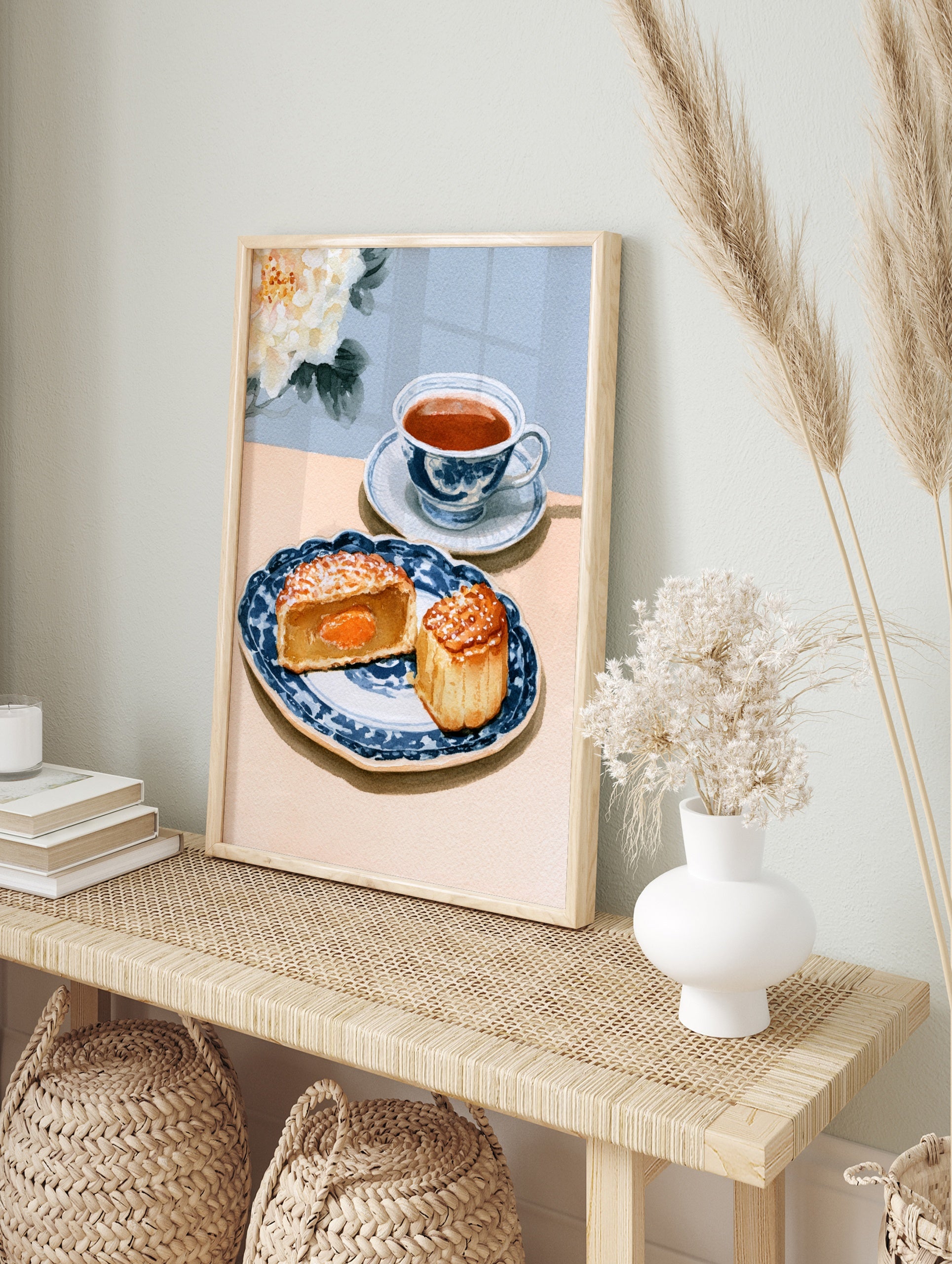 Watercolor illustration of a mooncake and teacup on a blue patterned plate with a white peony, in an alternate framed mockup