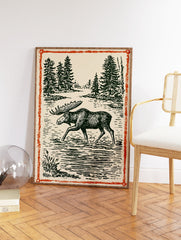 Vintage moose wall art illustration print showing a moose wading in a forest lake with pine trees and an orange border. - Image 2