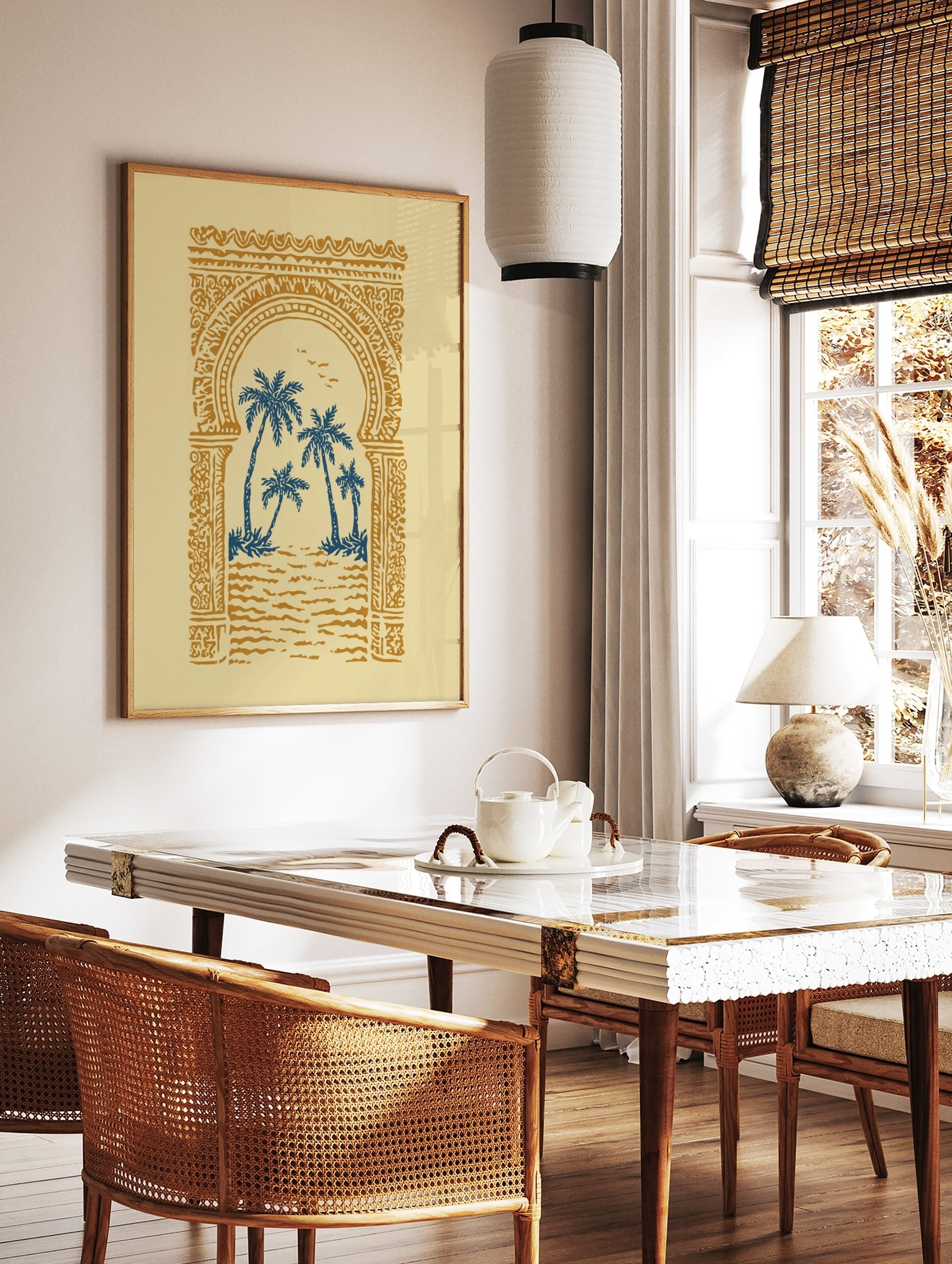 Illustrative print of blue palm trees through an ornate golden Moroccan archway on a cream, in a styled room mockup