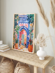 Vibrant Moroccan Archway Poster with blue intricate patterns, a pink wall, and lush green and orange potted plants. - Image 4
