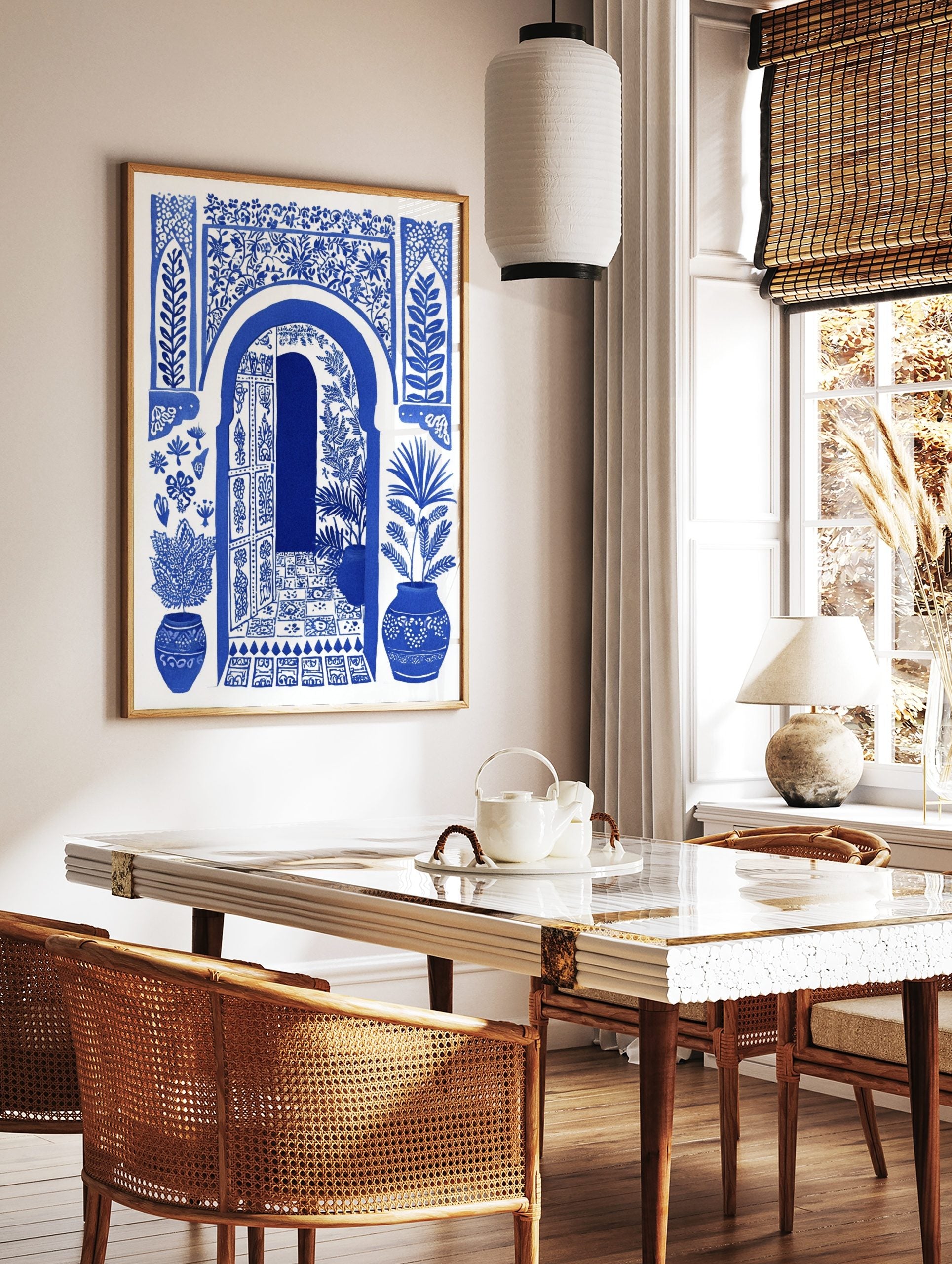 Blue and white illustrative art print of a Moroccan arched doorway with open door, botanical, in a styled room mockup