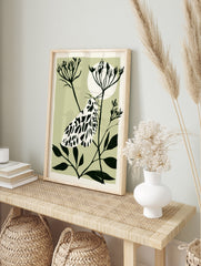 Illustrative moth botanical art print with black and white insect on a plant stem against a, in an alternate framed mockup