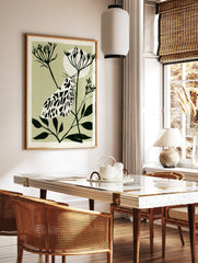 Illustrative moth botanical art print with black and white insect on a plant stem against a pale, in a styled room mockup