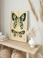 Vintage style moth illustration print with two insects in black ink on a cream background, in an alternate framed mockup