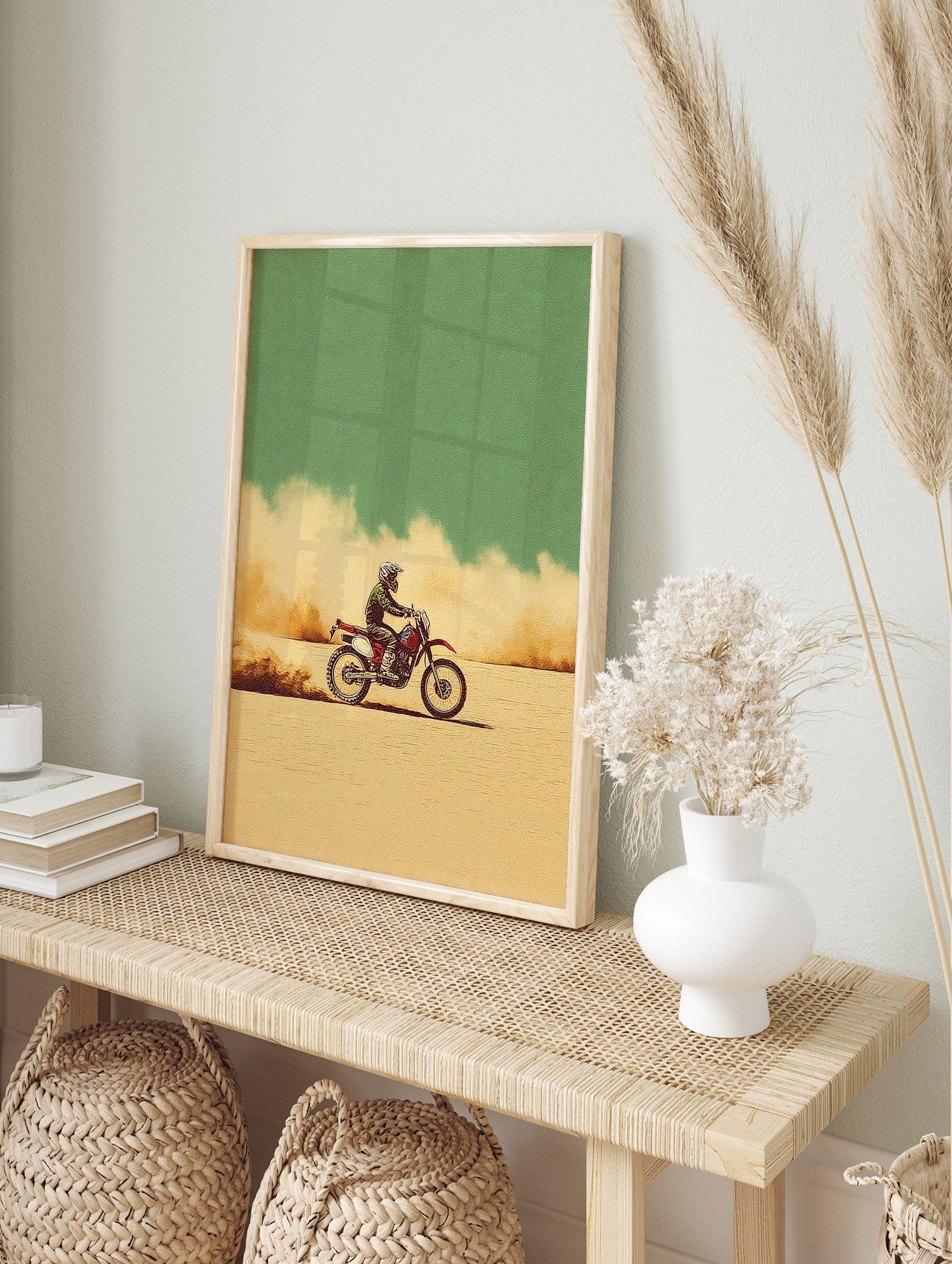 Illustrative motocross dirt bike rider on a red bike, kicking up dust in a beige desert under, in an alternate framed mockup