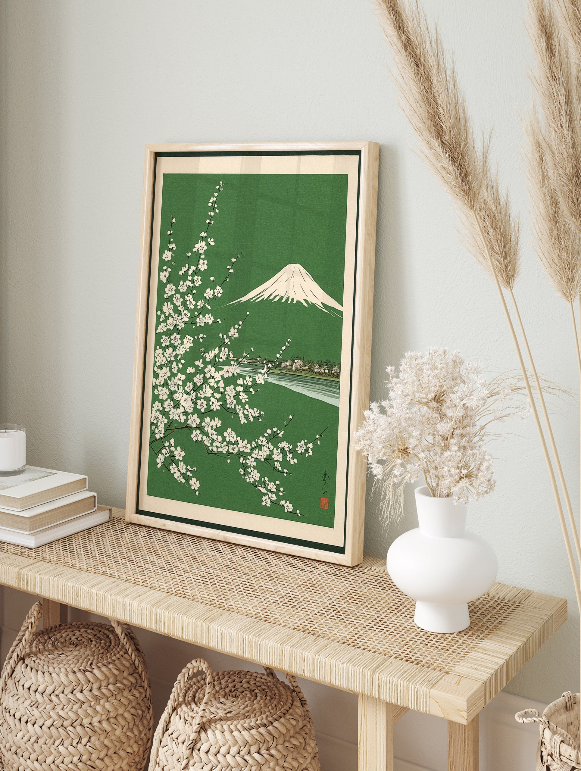 Japanese woodblock style print of Mount Fuji behind white cherry blossom branches on a green, in an alternate framed mockup