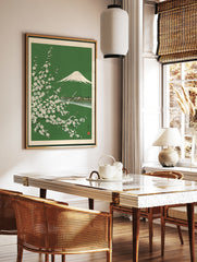 Japanese woodblock style print of Mount Fuji behind white cherry blossom branches on a green, in a styled room mockup