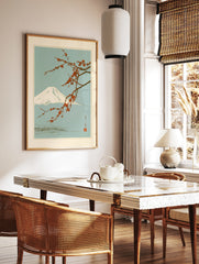 Japanese art print featuring a snow-capped Mount Fuji behind a branch of vibrant red plum blossoms, in a styled room mockup