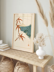 Japanese Mount Fuji landscape wall art with red bamboo leaves, a hut, and a stream in, in an alternate framed mockup