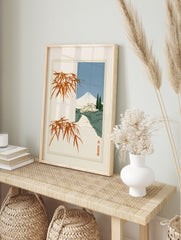 Japanese landscape art print with Mount Fuji, a traditional house, and orange bamboo branches, in an alternate framed mockup