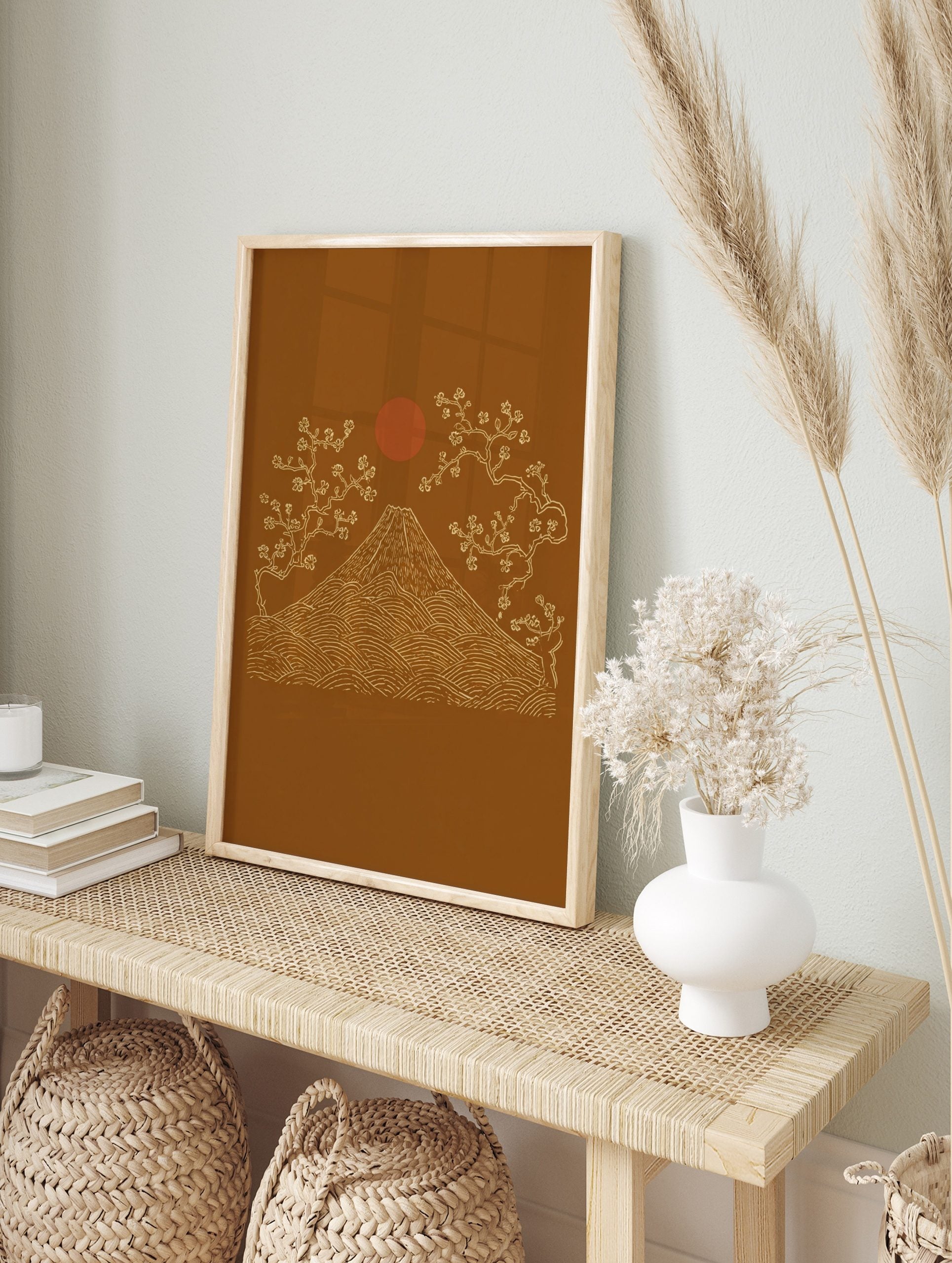 Illustrative Mount Fuji with cherry blossom trees and red sun on an ochre background in a, in an alternate framed mockup