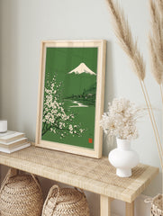 Japanese landscape art print with Mount Fuji, white blossoms, and a village on a green, in an alternate framed mockup