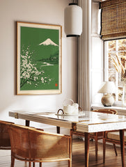 Japanese landscape art print with Mount Fuji, white blossoms, and a village on a green background, in a styled room mockup