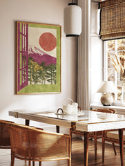 Illustrative Mount Fuji art print with magenta mountain, red sun, pine trees, and green border, in a styled room mockup