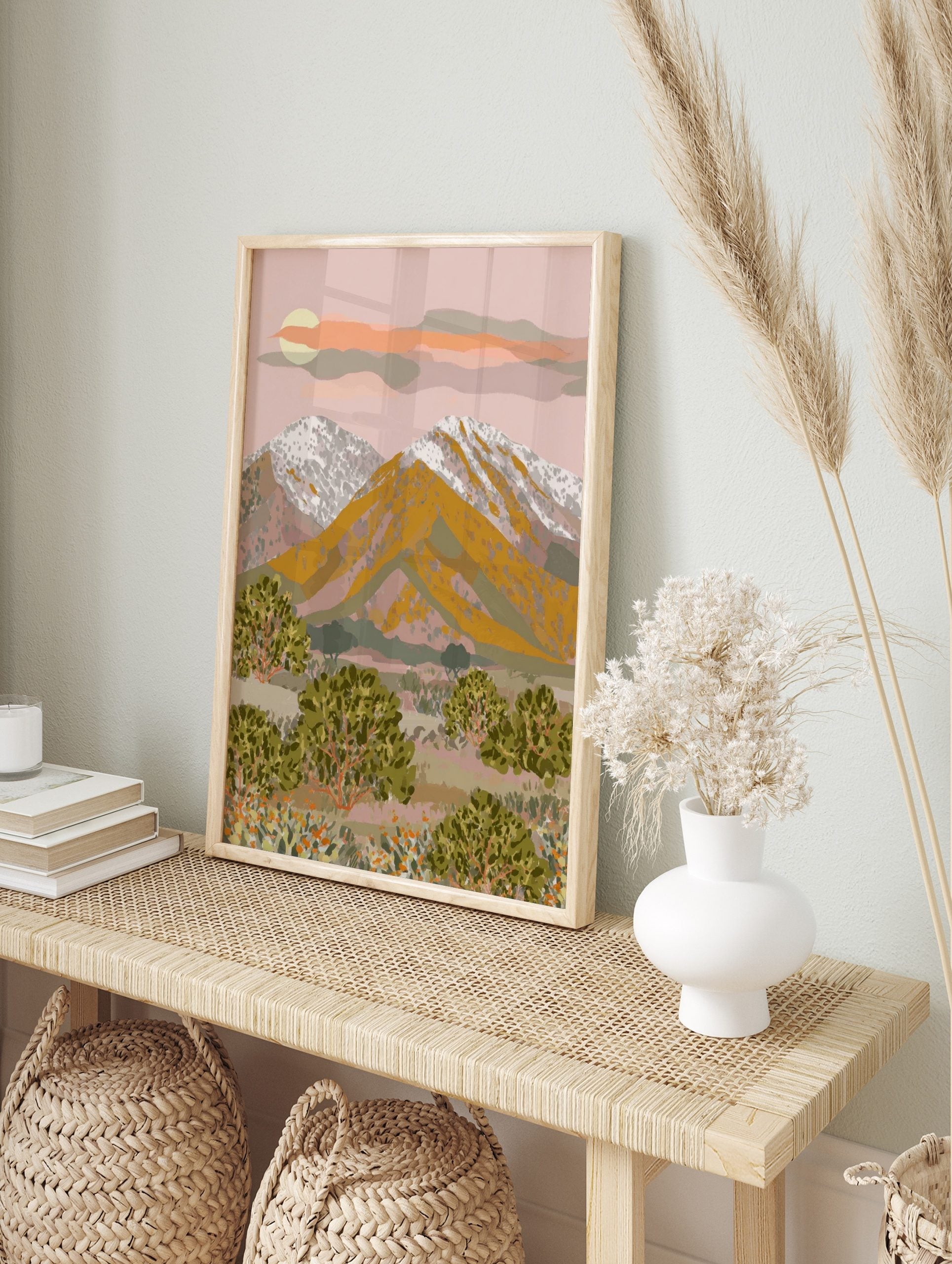 Illustrative mountain desert landscape art print with golden peaks, snow, green bushes, and, in an alternate framed mockup