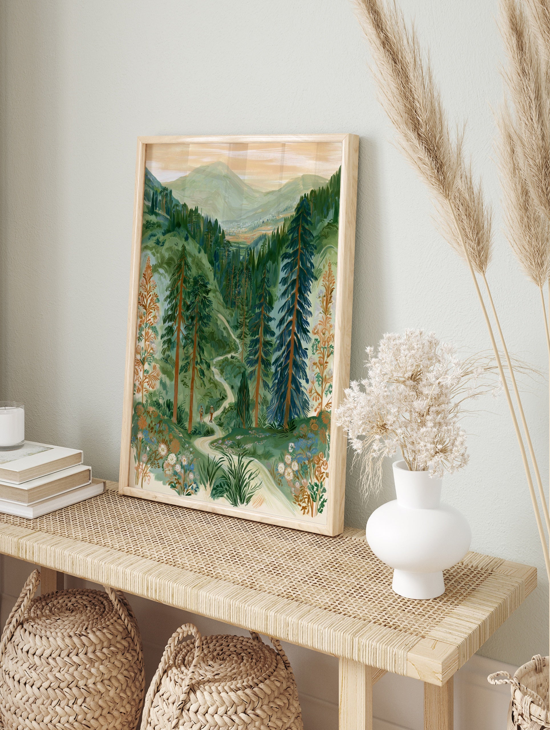 Illustration of two hikers on a winding path through a green mountain forest with wildflowers, in an alternate framed mockup