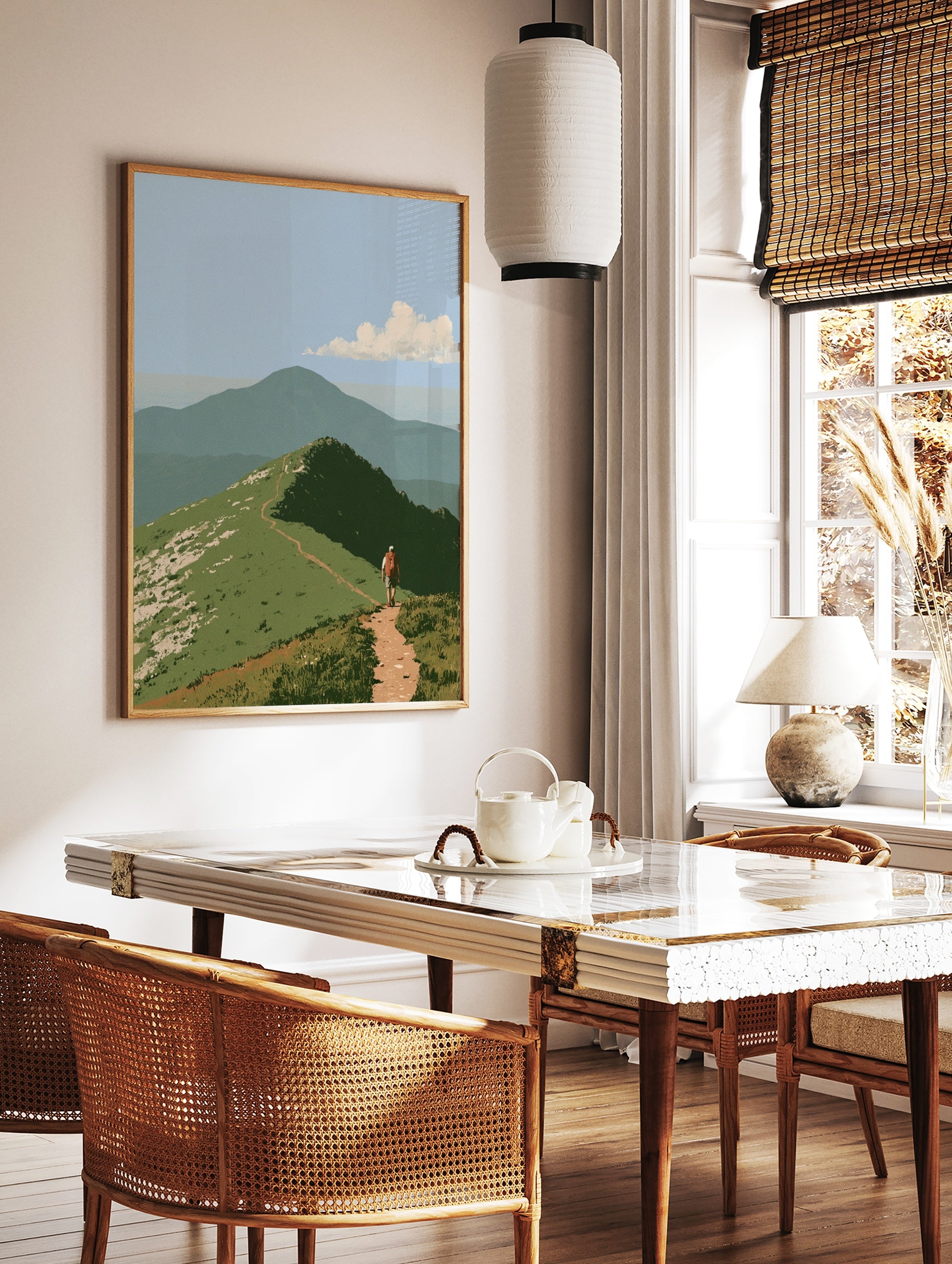 Illustrative mountain hiker wall art with a dirt trail on a grassy ridge and a distant peak under a, in a styled room mockup
