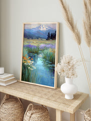 Impressionistic painting of a winding stream through a wildflower meadow towards a, in an alternate framed mockup