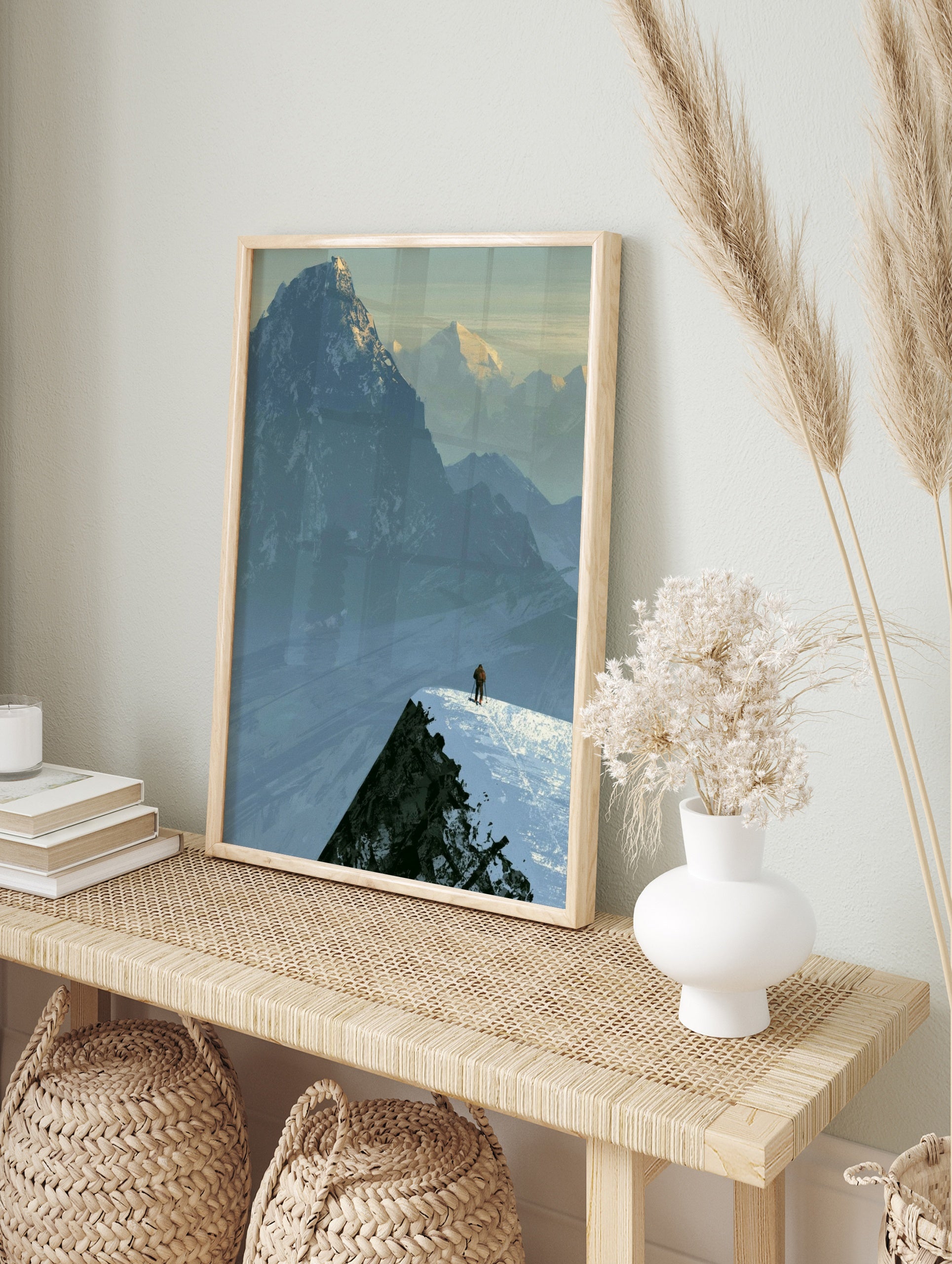Illustrative mountain landscape art print showing a lone skier on a snowy ridge against a, in an alternate framed mockup