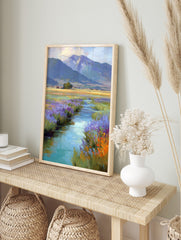 Impressionistic painting of a winding stream with purple and orange wildflowers leading to, in an alternate framed mockup