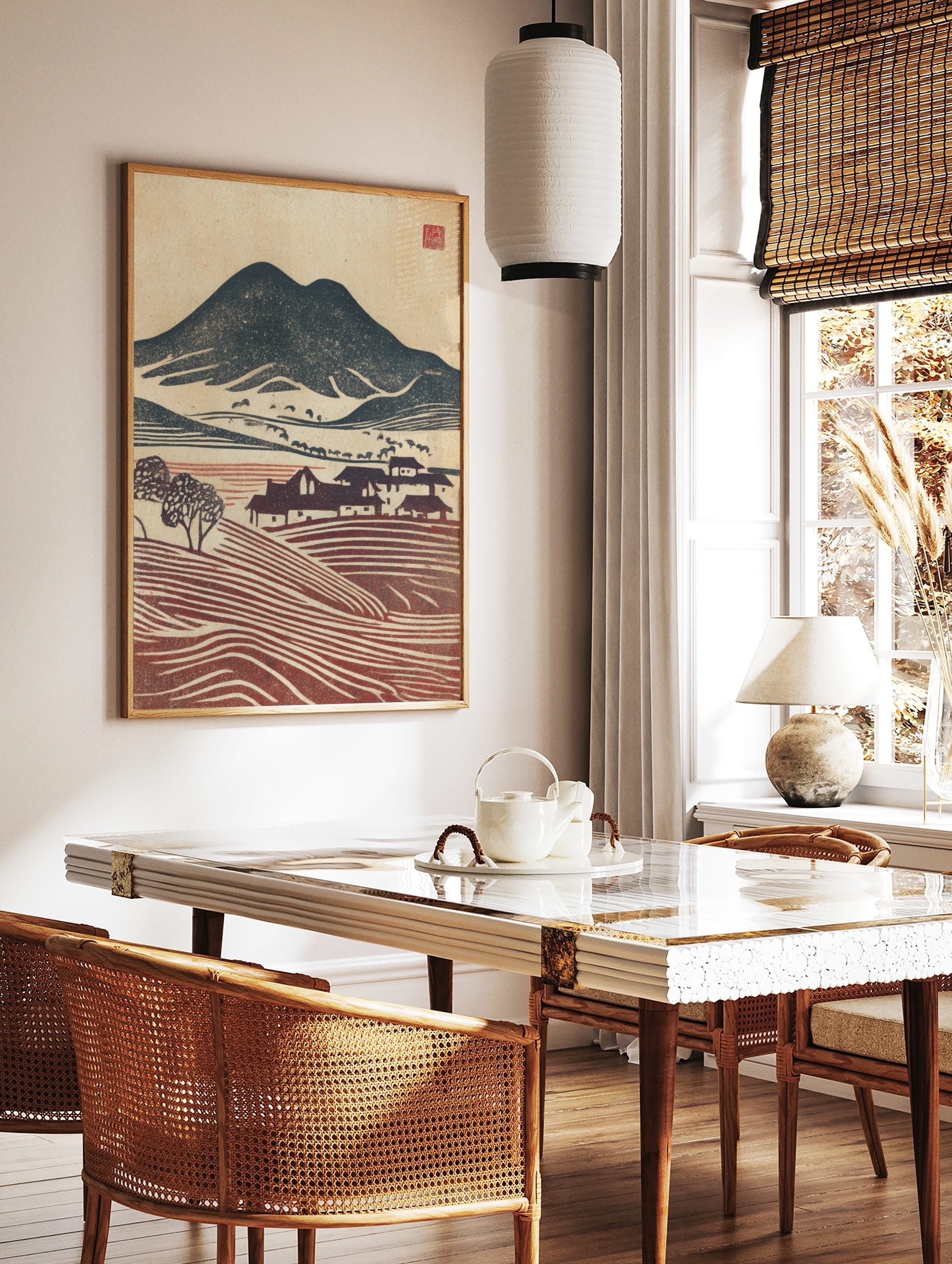 Woodblock print of navy mountains, red terraced fields, and houses in a rustic village landscape, in a styled room mockup