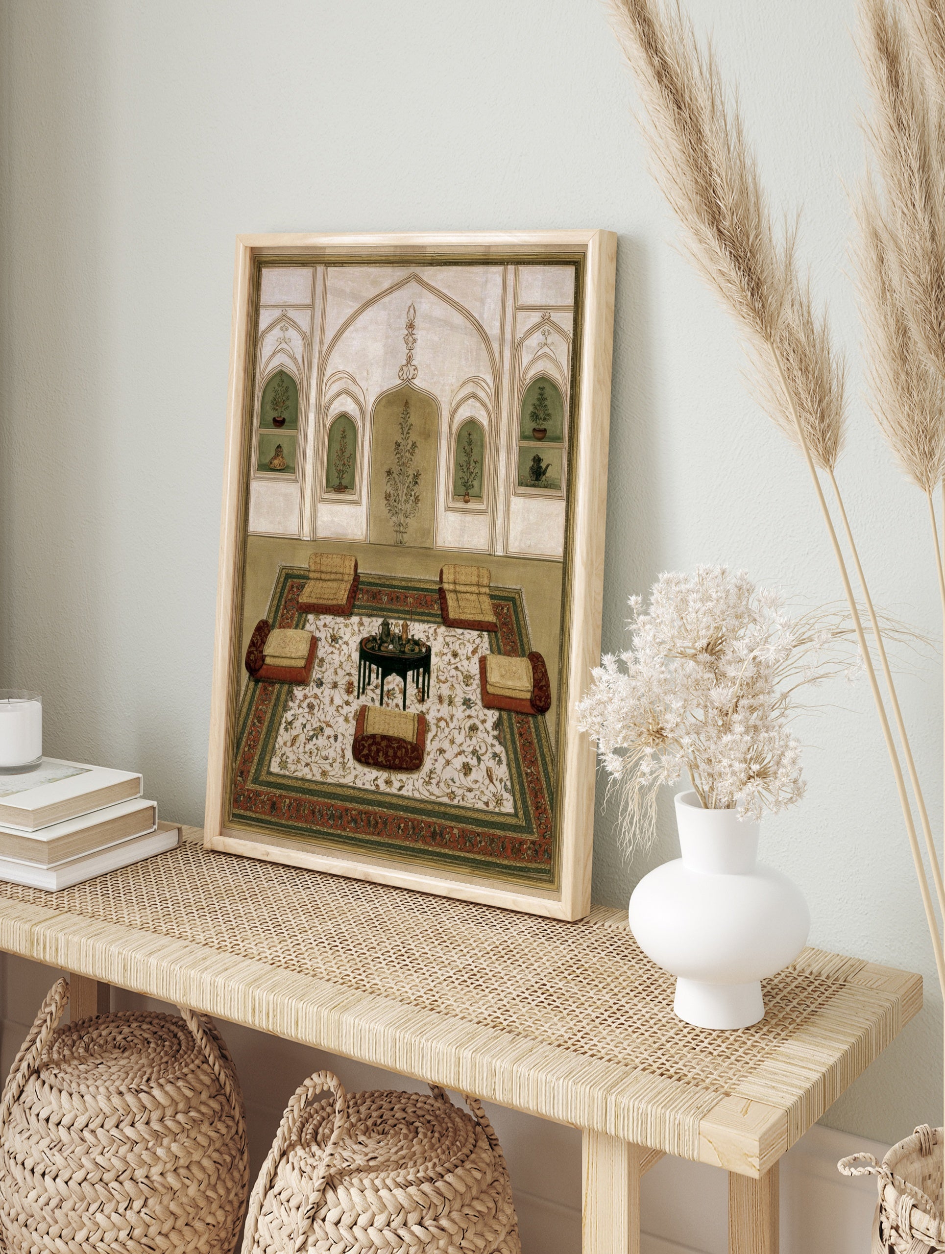 Mughal interior miniature painting with floor cushions, a central table, and floral arched, in an alternate framed mockup